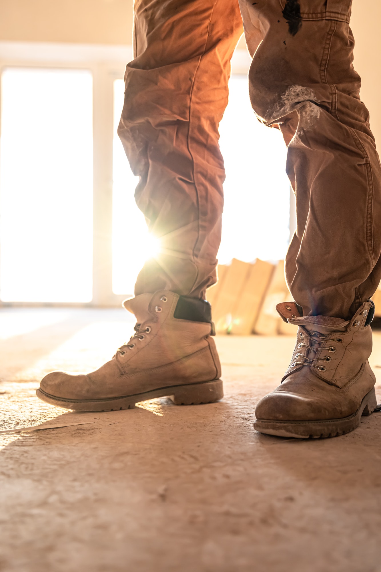 Close-up of work shoes of a builder at a construction site, copy space.